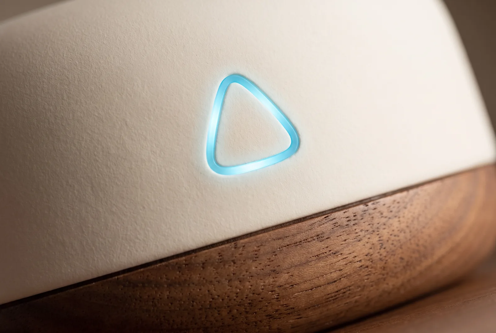 Macro of the hub's glowing triangle and the seam with the walnut base